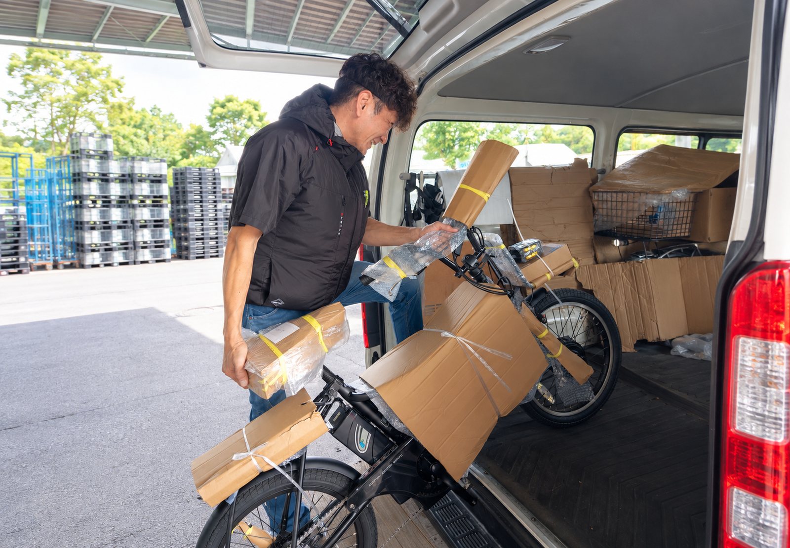配送車に電動アシスト自転車を積み込む株式会社ZAPのドライバー